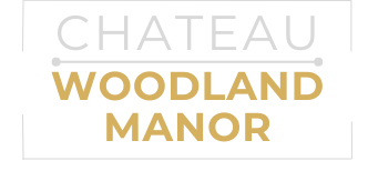 A green sign with the words "Chateau Woodland Manor" written in white.